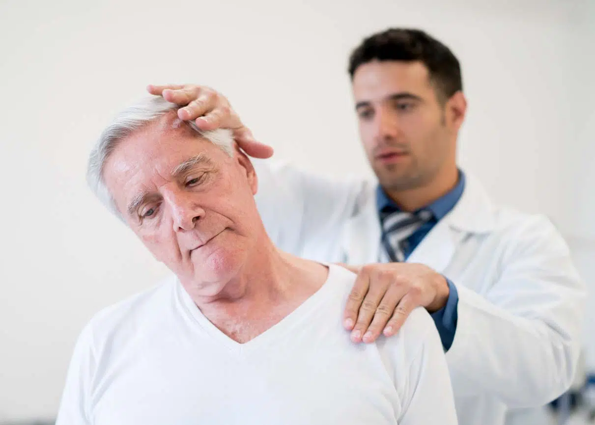 Senior man at the hospital doing physiotherapy for his neck - 