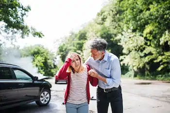 father helping his daughter get out of the car after auto accident