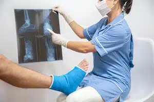 Bone fracture foot and leg on male patient being examined by a woman doctor in a hospital