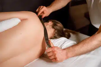 Physical therapist gives a special medical back massage using a IATSM to a woman