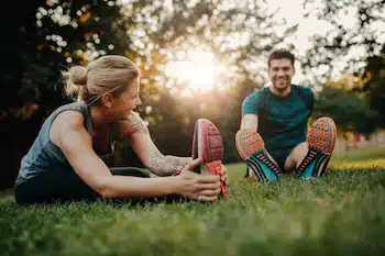 Young couple doing their stretches in the park