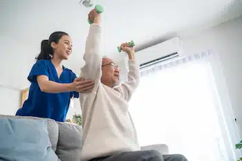 elderly man doing physical therapy with caregiver