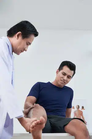 physiotherapist examining patients injury on leg