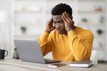 stressed man holding his head because of headache