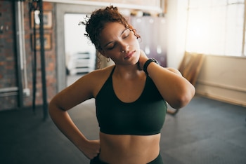 Woman stretching her neck in the gym
