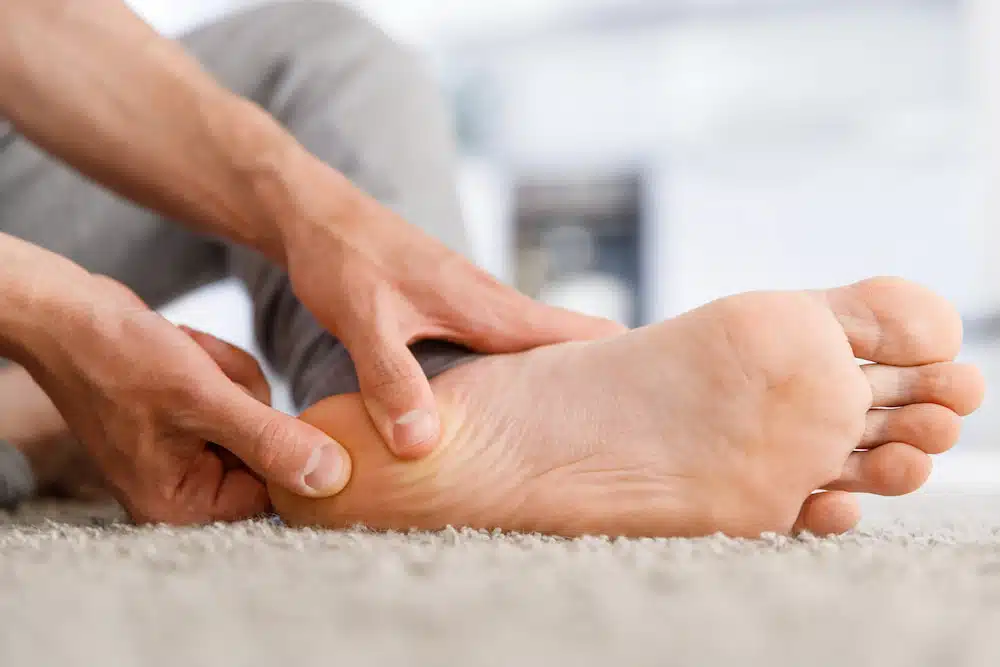 patient with Plantar Fasciitis massaging feet for Plantar Fasciitis treatment