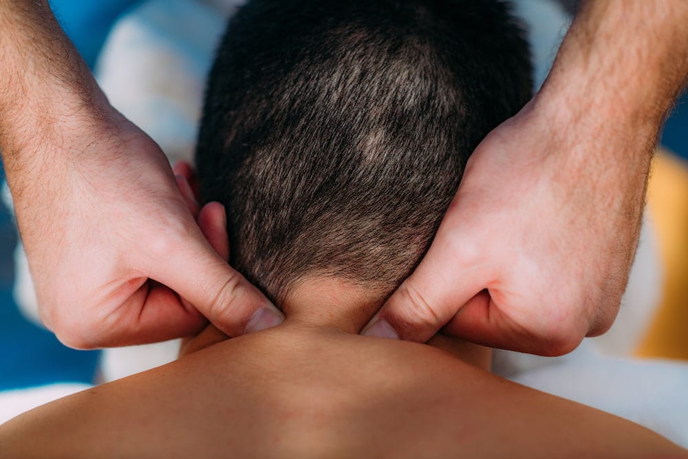 man's neck pressed by therapist for Physiotherapy for Whiplash