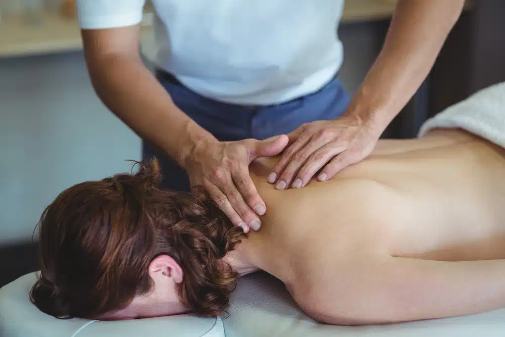therapist doing neck and back massage on woman  for Chiropractic Care and Physiotherapy for whiplash