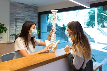 expert at chiropractic clinic explaining what to expect during decompression session to patient prior treatment