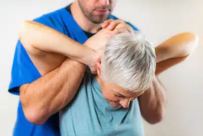 More Life Chiropractic | Experienced Chiropractor doing a stretch on a woman's shoulder for Shoulder Pain Treatment 