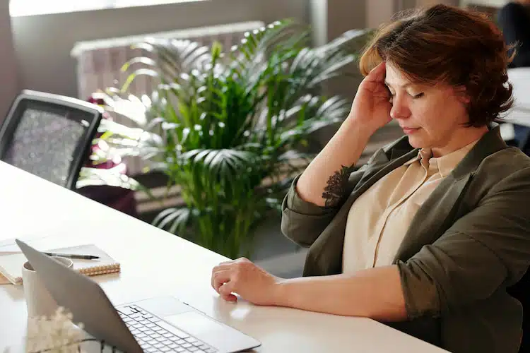 woman on front of a computer experiencing headache