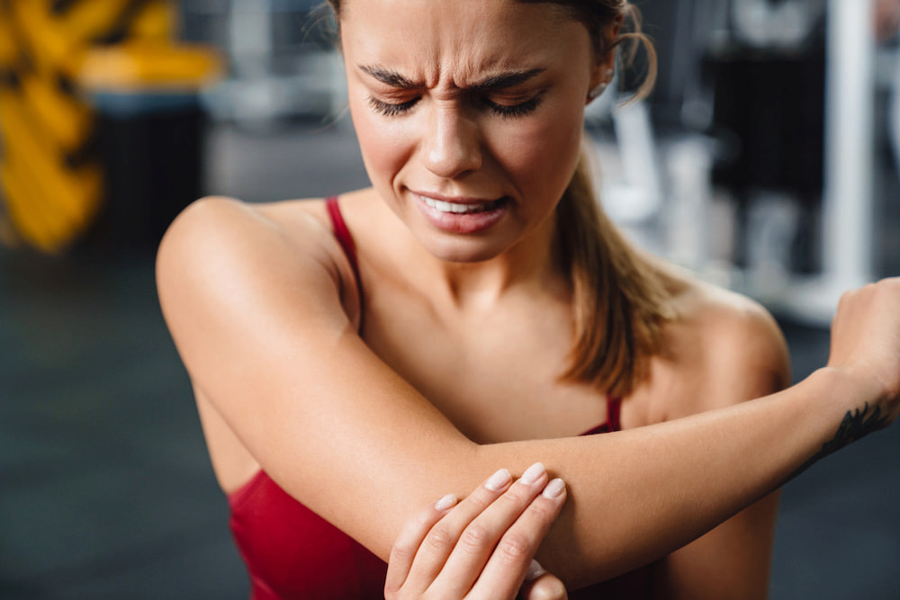 athletic woman experiencing elbow pain