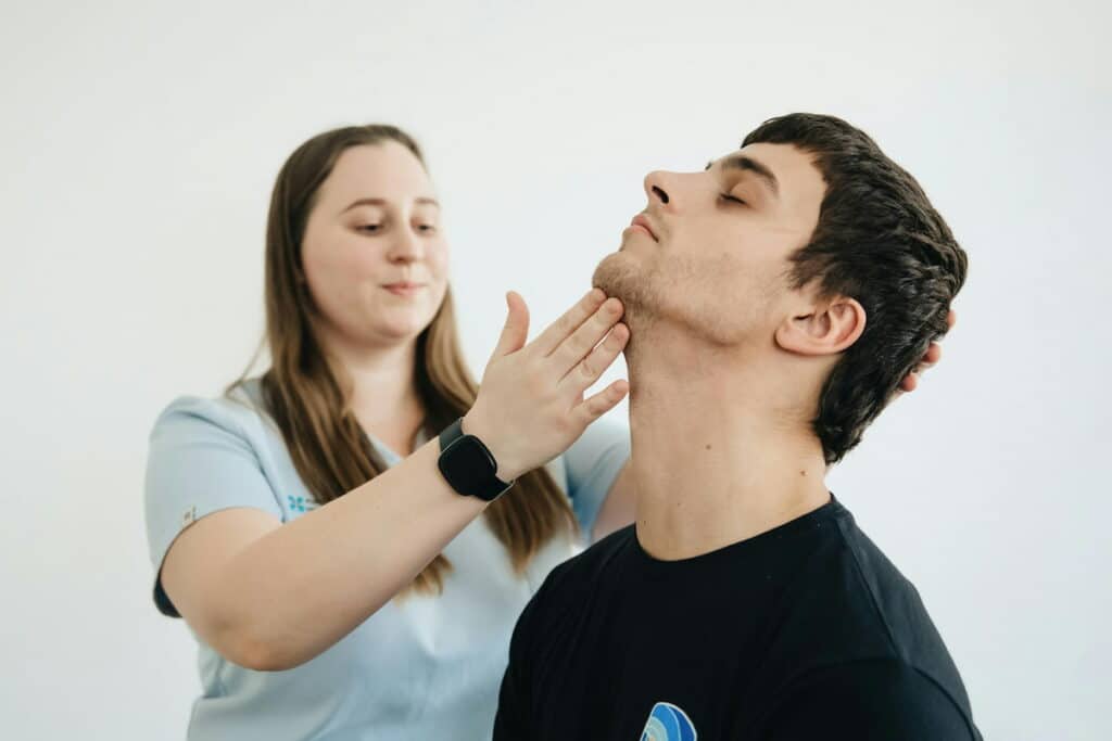 Physiotherapist Exercises with the Patient His Neck