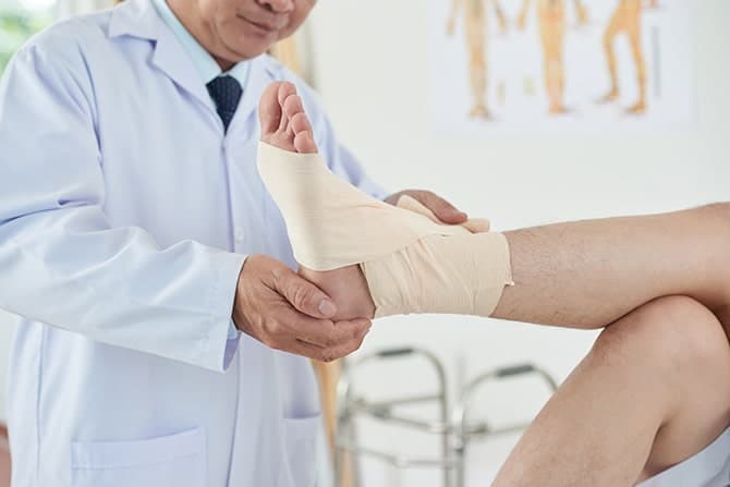 medical practitioner bandaging foot