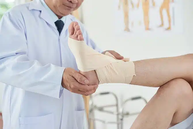 medical practitioner bandaging foot 