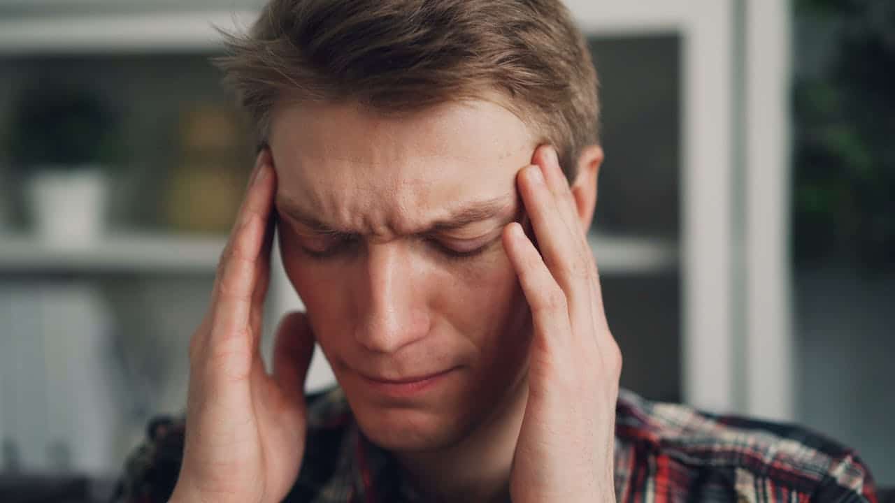 Man suffering from a cervicogenic headache in Burbank, CA, seeking migraine relief.
