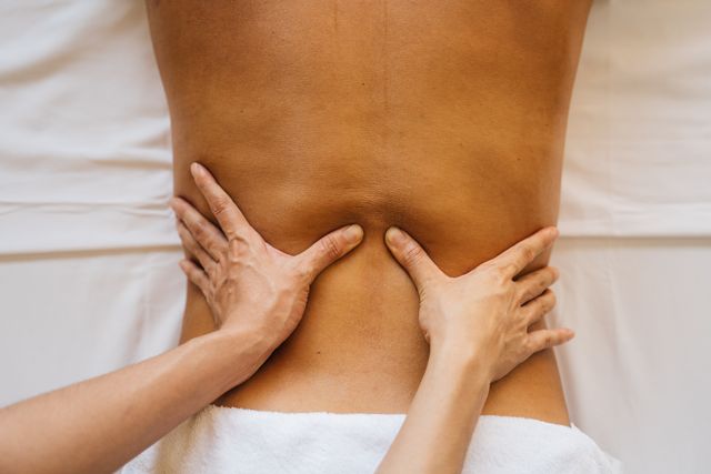 Chiropractor performing myofascial release and soft-tissue therapy for lower back pain relief.